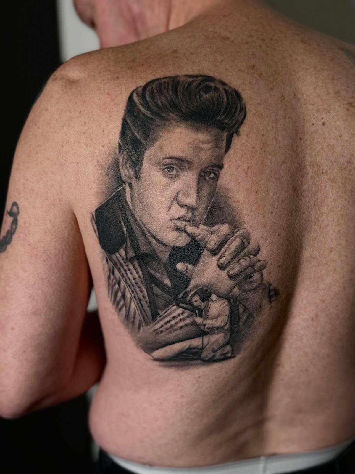 Black and grey portrait of Elvis Presley across the shoulder blade